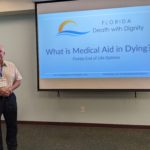 Image of Tony Ray standing next to the first slide of the Medical Aid in Dying presentation.